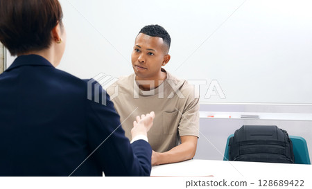 A black man and a Japanese female staff member having an interview 128689422