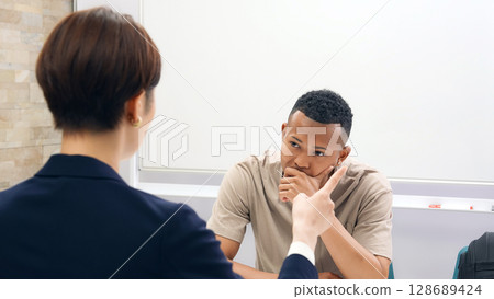 一名日本女工作人員正在採訪一名陷入困境的黑人男子 128689424