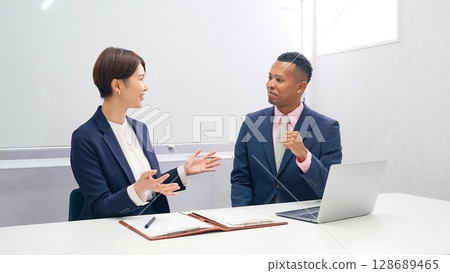 一名日本女工作人員正在採訪一名黑人男性商人 128689465