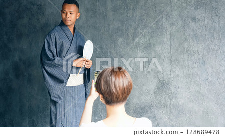 一名黑人請和服穿衣師幫他穿上浴衣 一名黑人請和服穿衣師幫他穿上浴衣 128689478