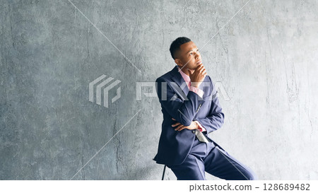 Black male businessman thinking in a dark room 128689482