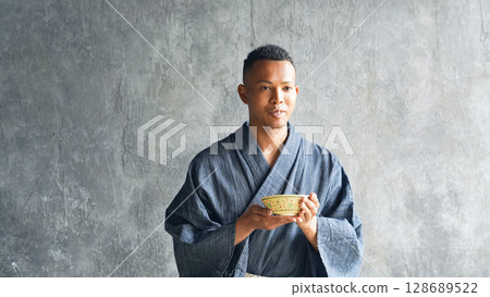 A black man wearing a yukata and experiencing a tea ceremony 128689522
