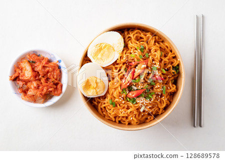 Spicy Korean dried instant noodles with boiled egg, scallions, sesame seed and chili  128689578