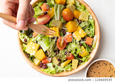 Top view of colorful vegetable salad in bowl with Japanese sesame dressing 128689585