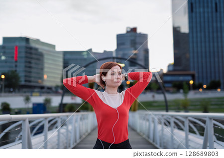 Sporty woman runner preparing for morning training, stretching. 128689803
