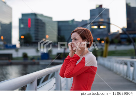 Sporty woman runner preparing for morning running workout. 128689804
