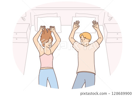 Happy couple lies on bed after checking into expensive hotel enjoying long-awaited vacation Happy couple lies on bed after checking into expensive hotel enjoying long-awaited vacation 128689900