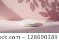 White round podium on pink surface with leaf shadows creating soft mood 128690189