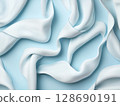 Soft white fabric flowing gently on light blue background creating calm and airy feeling 128690191