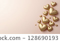 Golden heart shapes floating on soft pink background create warm romantic feeling 128690193