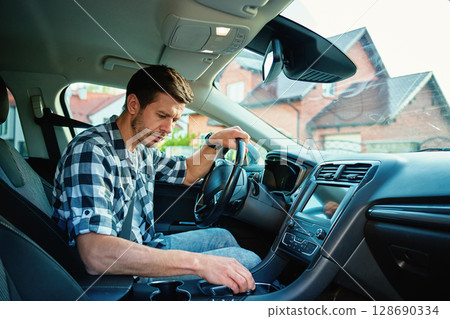 Man sitting in modern car and shifting gear with automatic gearbox. Person preparing for driving 128690334