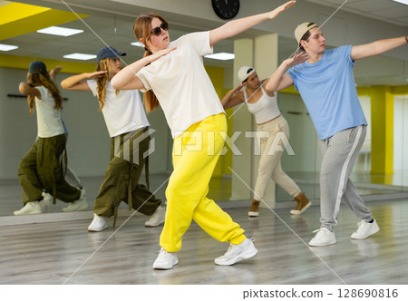 Young girl in sunglasses training breakdance Toprock moves in dance hall 128690816