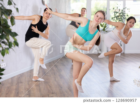 Girl teen perform choreographic exercise and teach energetic mobile social dance groove with friends 128690957
