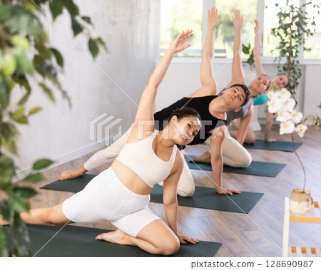 Asian female teenager performs deadbolt pose, parighasana 128690987