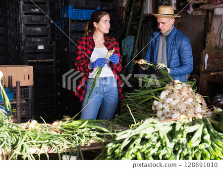 Farm family peeling and sorting freshly harvested spring onions Farm family peeling and sorting freshly harvested spring onions 128691010