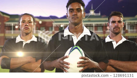 Image of glowing lights over diverse rugby players holding ball in rugby field 128691131