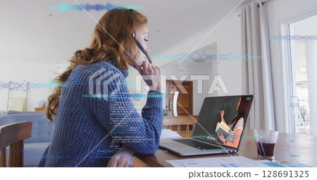 Image of data processing over caucasian woman working from home, having image call 128691325