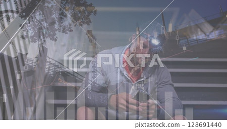 Image of financial data and graphs over caucasian man using smartphone 128691440