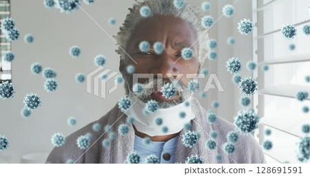 Standing senior man wearing bathrobe with mask pulled down at home, with virus particles overlay Standing senior man wearing bathrobe with mask pulled down at home, with virus particles overlay 128691591
