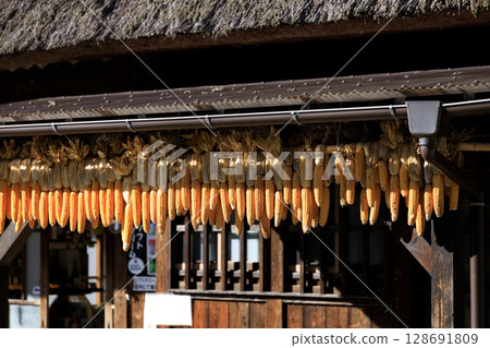 Old thatched roof house and autumn sky 128691809