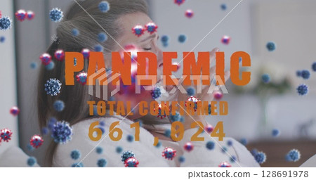 Coughing mature woman holding tissue on couch in living room, with virus and pandemic text overlay 128691978