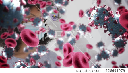 Showing masked gloved woman holding infrared thermometer indoors, with blood cells and coronavirus Showing masked gloved woman holding infrared thermometer indoors, with blood cells and coronavirus 128691979