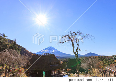 Mount Fuji in the early autumn morning through an old thatched roof house 128692511