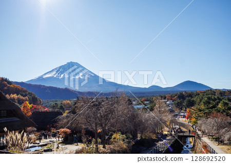 Mount Fuji in the early autumn morning through an old thatched roof house Mount Fuji in the early autumn morning through an old thatched roof house 128692520