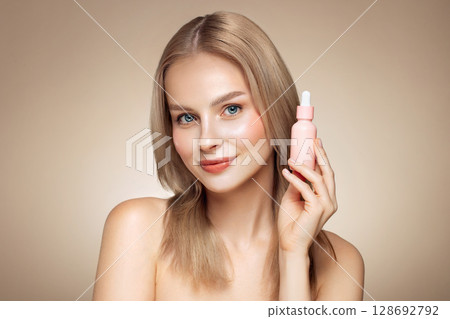 Woman holding a cosmetic jar of oil serum Woman holding a cosmetic jar of oil serum 128692792