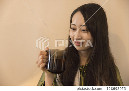 Image of a woman hydrating while taking a mugwort steam bath 128692953