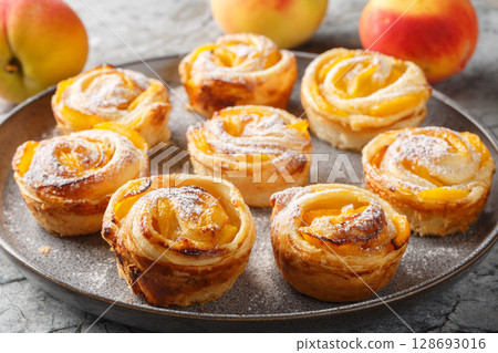 puff pastry peach roses mini tarts muffins close-up on a plate. horizontal 128693016