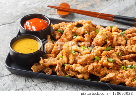 Xiaosurou little crispy pork, is deep-fried fatty pork studded with plenty of numbing Sichuan pepper closeup on the plate. Horizontal Xiaosurou little crispy pork, is deep-fried fatty pork studded with plenty of numbing Sichuan pepper closeup on the plate. Horizontal 128693028