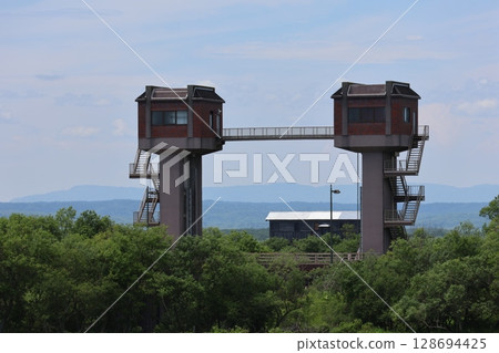 Iwaboki Water Gate towering over the Kushiro Marshland. From the train window on the JR Senmo Main Line. Iwaboki Water Gate towering over the Kushiro Marshland. From the train window on the JR Senmo Main Line. 128694425