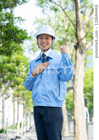 身穿工作服的中年男子，握拳 128694468