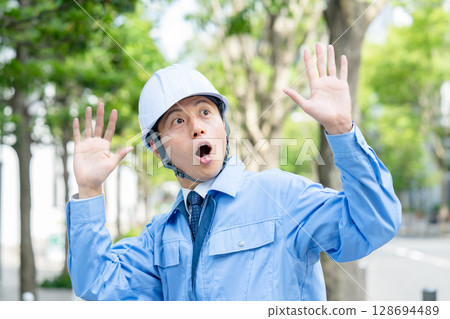 Middle-aged man in work clothes is surprised 128694489