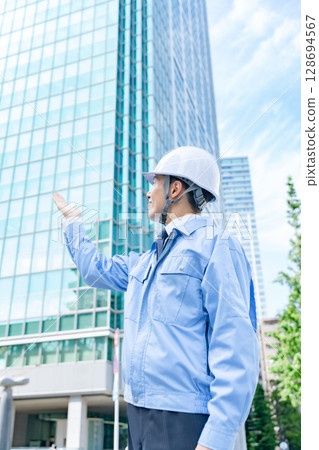 Middle-aged man in work clothes waving his hands 128694567