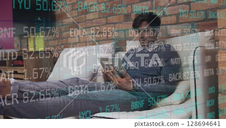 Image of financial data over caucasian businessman using tablet 128694641