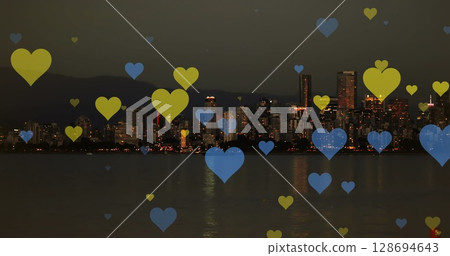 Image of yellow and blue hearts floating over night cityscape Image of yellow and blue hearts floating over night cityscape 128694643