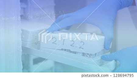 Image of mathematical equations over scientist in lab 128694795