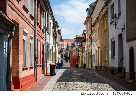 Colorful old residential street with cobblestone pavement and historic facades in Wismar, Germany 128696462