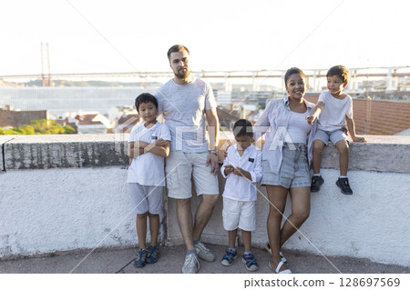 Family enjoying summer holidays in lisbon, portugal, posing near 25 de abril bridge 128697569