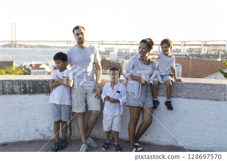 Happy family enjoying view of lisbon cityscape with 25 de abril bridge in background 128697570