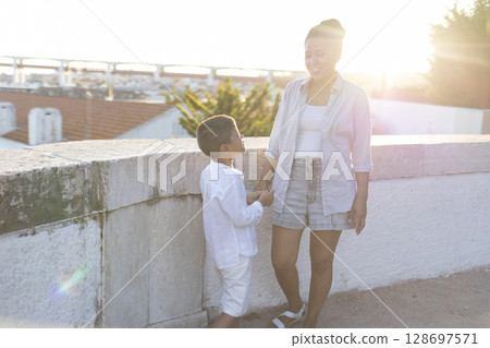 Mother and son holding hands, enjoying sunny day in lisbon 128697571