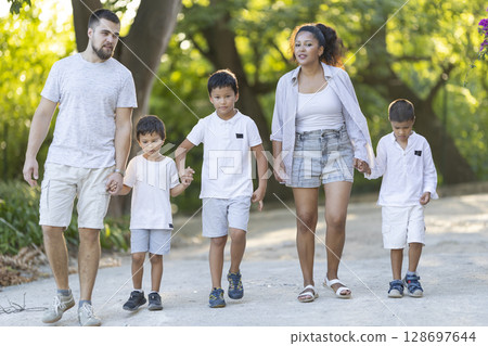 Happy family walking in park holding hands 128697644