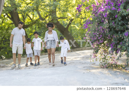 Family enjoying walking together in park on summer day Family enjoying walking together in park on summer day 128697646