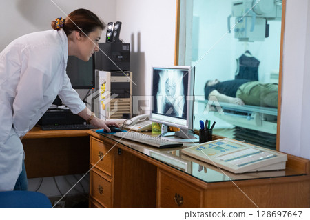 Radiologist Analyzing X-Ray Scans in a Medical Imaging Room. 128697647