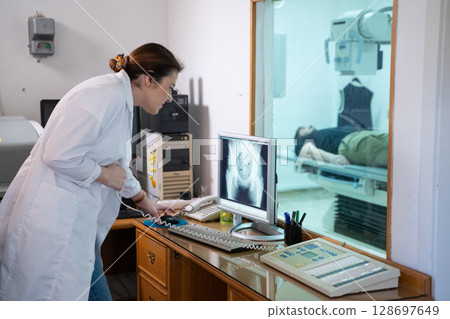 Radiologist Analyzing X-Ray Scans in a Medical Imaging Room. 128697649