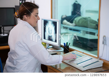 Radiologist Analyzing X-Ray Scans in a Medical Imaging Room. Radiologist Analyzing X-Ray Scans in a Medical Imaging Room. 128697653