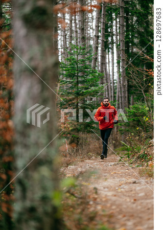 Jogger in Autumn Forest Trail 128697683