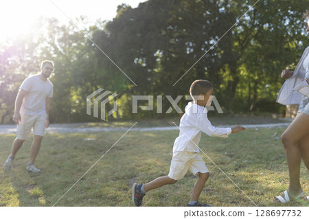 Happy family playing and running in park during summer 128697732